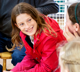 Young girl on a ferry smiling at a friends