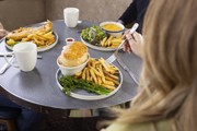 three people sitting in Mariners Cafe eating food