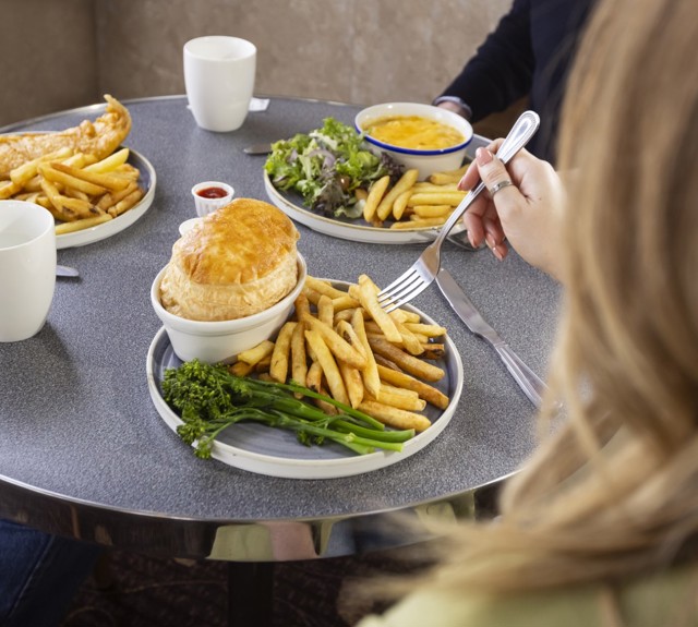 three people sitting in Mariners Cafe eating food