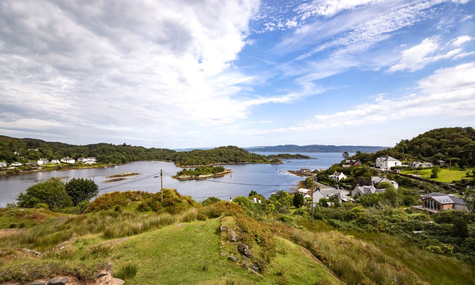 A hilltop view looking towards Tarbert in Kintyre, white houses and across the water.