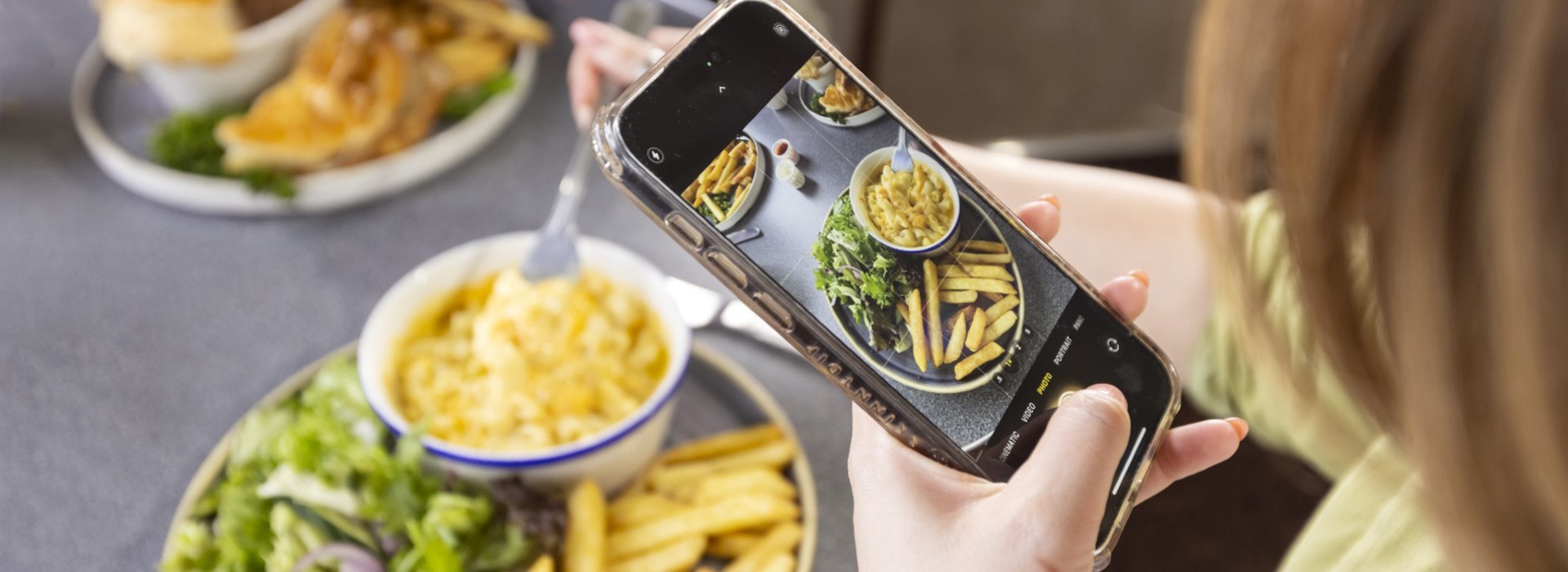 someone taking an image of their mac and cheese on their mobile phone