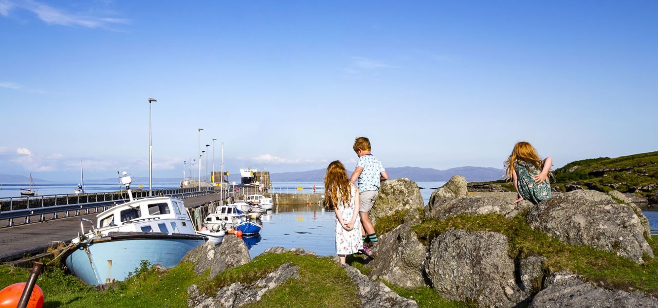 Children exploring the harbourside of Colonsay on a summer day