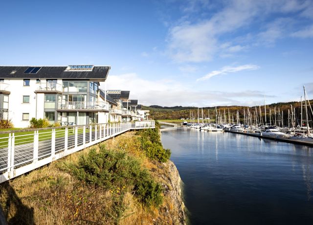 Portavidie Marina with a row of sail boats across from the Marina accommodationa and restaurant