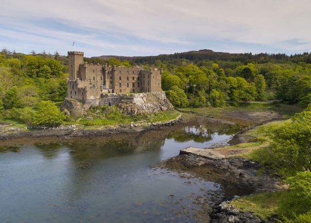 Dunvegan Castle sitting high up within the woodland and gardens, Skye.