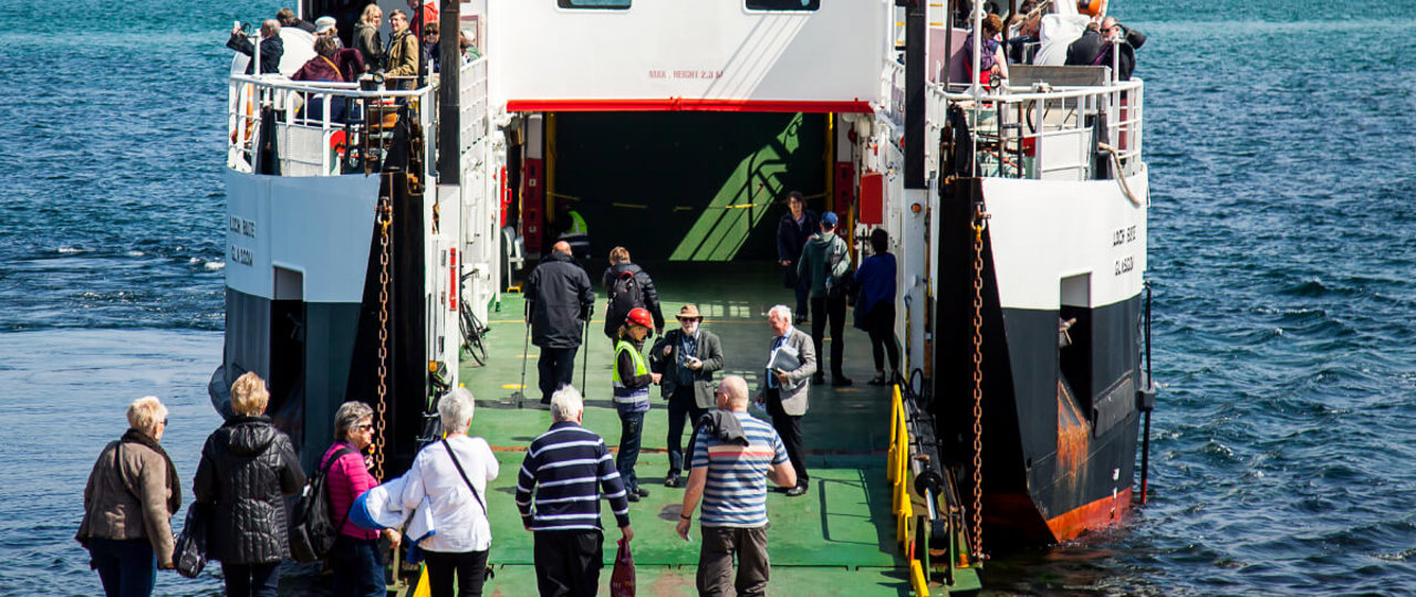 Group of elderly people walking onto a ferry