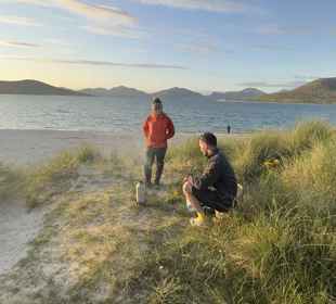 Two people enjoying an hot drink on a beach in Harris