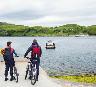 Father and on bikes at the slipway waiting for the ferry to arrive