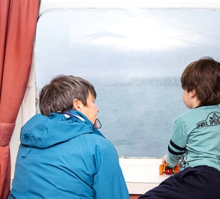 woman and little boy looking out of window