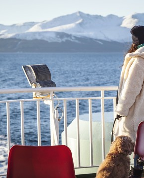 lady and her dog looking out from the deck of the boat