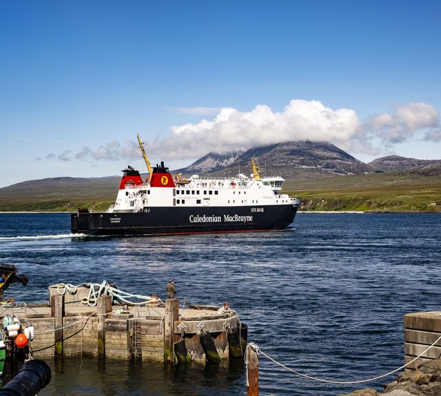 The MV Finlaggan leaving harbour with the cloud covered Paps of Jura in the backgound